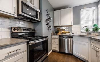 A modern kitchen with a stove, oven, and microwave